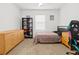 Relaxing bedroom with a dresser, shelf, neutral-toned walls, a window, and a gaming chair at 5659 Woodland Sage Dr, Sarasota, FL 34238