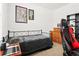 Comfortable bedroom with a simple bed frame, gaming chair, dresser, and wall decor at 5659 Woodland Sage Dr, Sarasota, FL 34238