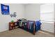 Bedroom featuring fun sports decor, window and hardwood dresser at 5659 Woodland Sage Dr, Sarasota, FL 34238