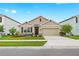 Charming single-Gathering home featuring a well-manicured lawn, neutral exterior, and a two-car garage at 5659 Woodland Sage Dr, Sarasota, FL 34238