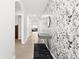 Open hallway with tile flooring, modern console table, and stylish wallpaper, leading to various rooms at 5659 Woodland Sage Dr, Sarasota, FL 34238