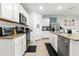 Bright kitchen with stainless steel appliances, granite counters, and white cabinets at 5659 Woodland Sage Dr, Sarasota, FL 34238