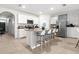 Spacious kitchen featuring an island with bar stools, stainless steel appliances, and white cabinetry at 5659 Woodland Sage Dr, Sarasota, FL 34238