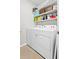 Bright laundry area with a stacked washer and dryer and plenty of storage shelves for laundry supplies at 5659 Woodland Sage Dr, Sarasota, FL 34238