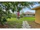 Backyard with a mature tree, a table with umbrella, and a walkway leading towards the house at 5823 Helen Way, Sarasota, FL 34243