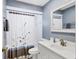 Cozy bathroom featuring a white vanity, framed mirror and a shower with a patterned curtain at 5823 Helen Way, Sarasota, FL 34243
