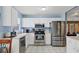 Modern kitchen boasts white cabinets, stainless steel appliances and tiled floor at 5823 Helen Way, Sarasota, FL 34243