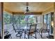Covered patio featuring tile floors, a ceiling fan, and a glass-top table with seating for six at 5823 Helen Way, Sarasota, FL 34243