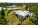Aerial shot showcasing a home with a modern roof, fenced backyard with patio, set among mature trees and lush greenery at 601 Suffolk Cir, Nokomis, FL 34275