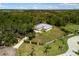 Expansive aerial view of a secluded property with a long driveway and lush greenery surrounding the residence at 601 Suffolk Cir, Nokomis, FL 34275