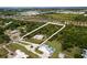 Aerial view of a secluded property surrounded by mature trees, a long driveway, and meticulous landscaping at 601 Suffolk Cir, Nokomis, FL 34275