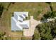 An overhead shot revealing a modern home with a gray roof, concrete driveway, and surrounded by lush greenery at 601 Suffolk Cir, Nokomis, FL 34275