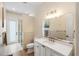 Bright bathroom featuring a double sink vanity, modern lighting, and a glass-enclosed shower at 601 Suffolk Cir, Nokomis, FL 34275