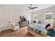 Bright bedroom featuring hardwood floors, a ceiling fan, and a workspace near the natural light from the windows at 601 Suffolk Cir, Nokomis, FL 34275