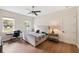 Bright bedroom featuring hardwood floors, a ceiling fan, and a workspace near the natural light from the windows at 601 Suffolk Cir, Nokomis, FL 34275