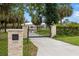 Gated driveway entrance with lush landscaping and an inviting path leading to the residence at 601 Suffolk Cir, Nokomis, FL 34275
