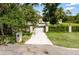 Long private driveway leading to a well-maintained home with beautiful landscaping and a secure gate at 601 Suffolk Cir, Nokomis, FL 34275