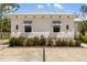 Charming home exterior with white stucco, modern windows with awnings, and manicured landscaping for a serene curb appeal at 601 Suffolk Cir, Nokomis, FL 34275