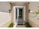Stylish front door with sidelight, decorative stonework, and elegant outdoor lighting fixtures create a welcoming entrance at 601 Suffolk Cir, Nokomis, FL 34275
