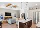Stylish kitchen open to living area with eat-in island, wood ceiling beams, and modern fireplace at 601 Suffolk Cir, Nokomis, FL 34275