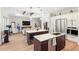 Open-concept living space with kitchen island, stainless sink, and cozy living area with fireplace at 601 Suffolk Cir, Nokomis, FL 34275