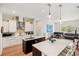 Bright open living space with kitchen island, black sofa, piano and views of the backyard at 601 Suffolk Cir, Nokomis, FL 34275