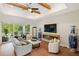 Spacious living room with a fireplace, sliding glass doors, hardwood floors, and neutral decor offer comfort and style at 601 Suffolk Cir, Nokomis, FL 34275