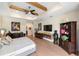 Bright main bedroom featuring wood-look floors, a tray ceiling with beams, and a cozy fireplace at 601 Suffolk Cir, Nokomis, FL 34275