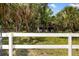 Scenic view of the property line framed by a classic white fence and verdant landscaping at 601 Suffolk Cir, Nokomis, FL 34275