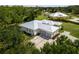 Beautiful rear exterior showcasing a three-car garage, a metal roof, and ample green space at 601 Suffolk Cir, Nokomis, FL 34275