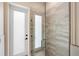 Walk in shower with decorative tile surround and glass door near exterior access at 601 Suffolk Cir, Nokomis, FL 34275