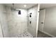 This bathroom features a spacious marble-tiled shower with a pebble floor and built-in shelving at 6400 46Th N Ave # 113, Kenneth City, FL 33709