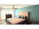 Bright bedroom with a tufted headboard, ceiling fan, and large window for natural light at 6400 46Th N Ave # 113, Kenneth City, FL 33709