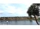 Exterior view of the apartment complex overlooking a scenic lake with palm trees at 6400 46Th N Ave # 113, Kenneth City, FL 33709