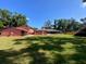 Expansive backyard featuring a lush lawn, mature trees, and an outbuilding at 6923 13Th E Ave, Bradenton, FL 34208