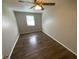 Well-lit bedroom featuring a ceiling fan, hardwood floors, and a window providing natural light at 6923 13Th E Ave, Bradenton, FL 34208