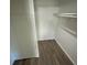 Spacious walk-in closet featuring ample storage with hardwood floors and built-in shelving at 6923 13Th E Ave, Bradenton, FL 34208
