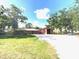 Charming home exterior featuring a spacious yard, mature trees, and an adjacent barn at 6923 13Th E Ave, Bradenton, FL 34208
