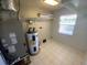 Clean, tiled utility room features a water heater, HVAC system, and natural light at 6923 13Th E Ave, Bradenton, FL 34208