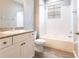 Well-lit bathroom features a granite vanity, white cabinets, and a shower-tub combo with tile surround at 7113 Park Tree Dr, Tampa, FL 33625