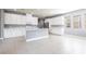 Spacious open kitchen with white cabinetry, stainless steel appliances, a kitchen island, and tile flooring at 7113 Park Tree Dr, Tampa, FL 33625