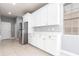 Bright kitchen showcasing white cabinets, stainless steel refrigerator, ample counter space, and tile floors at 7113 Park Tree Dr, Tampa, FL 33625