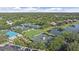 An aerial view of tennis courts at the University Park Country Club surrounded by lakes and greenery at 7507 Ascot Ct, University Park, FL 34201