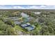 Aerial view of tennis courts at the University Park Country Club surrounded by trees and a lake at 7507 Ascot Ct, Bradenton, FL 34201