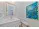 Bathroom featuring a white vanity, a toilet, artwork, and a view of the closet through the mirror at 7507 Ascot Ct, University Park, FL 34201