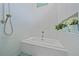 Modern bathroom featuring a built-in tub, a tiled wall, and a view of the shower at 7507 Ascot Ct, University Park, FL 34201