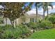 Charming home exterior showcasing meticulously kept landscaping, trees, and a stone walkway at 7507 Ascot Ct, Bradenton, FL 34201