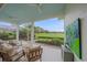 Screened-in patio featuring comfortable seating and serene views of the lush backyard and golf course at 7507 Ascot Ct, University Park, FL 34201