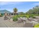 Well-maintained outdoor patio area with comfortable seating, lush landscaping, and a view of the clubhouse at 7507 Ascot Ct, Bradenton, FL 34201