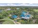 Expansive aerial view of the clubhouse surrounded by a lake, golf course and lush greenery at 7507 Ascot Ct, University Park, FL 34201
